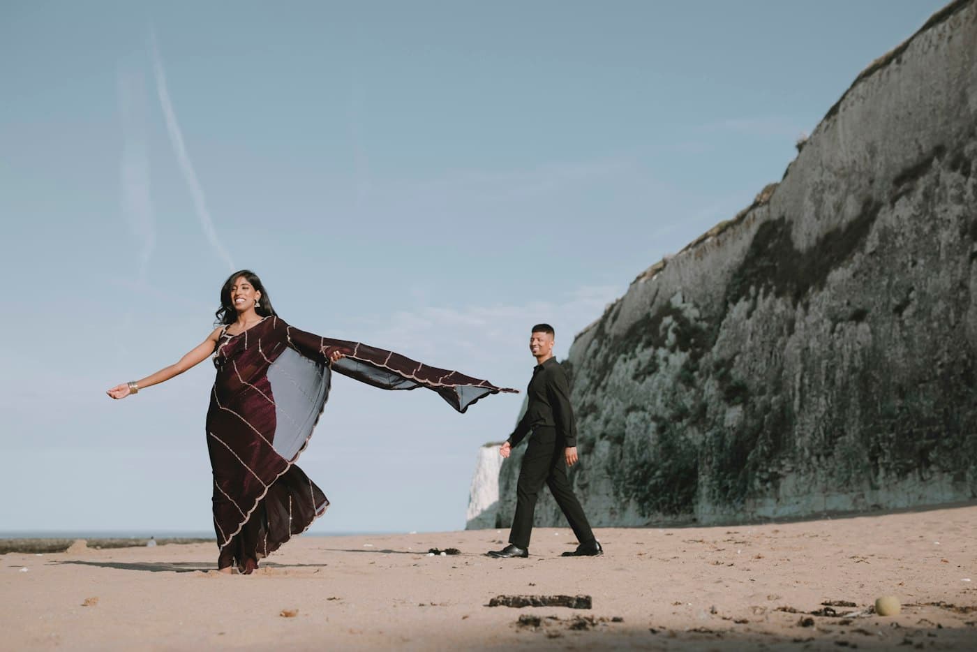 A couple on a cliff above a beach